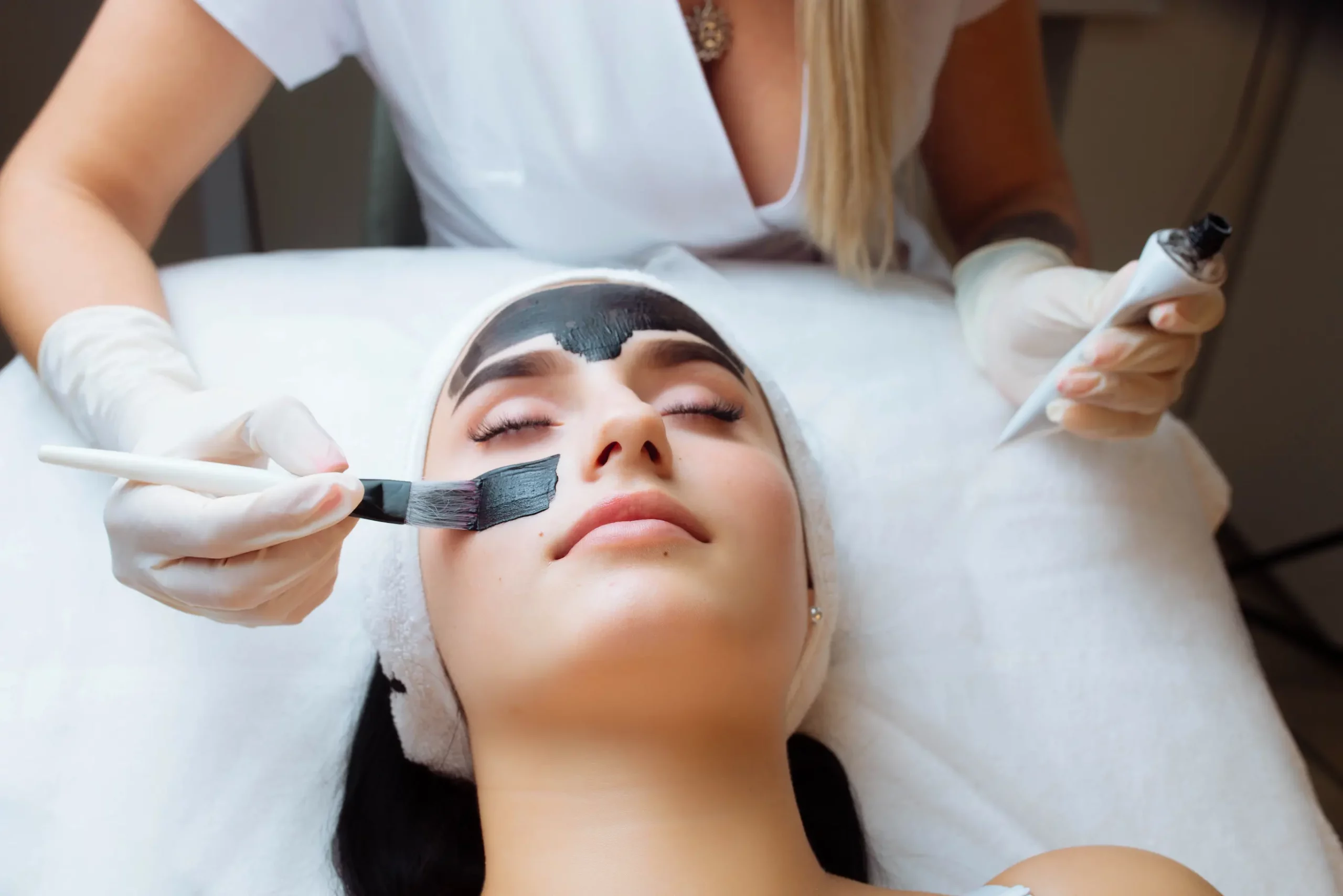 Kosmetikerin trägt eine pflegende Gesichtsmaske während einer professionellen Gesichtsbehandlung bei Maison Sanae in Graz auf